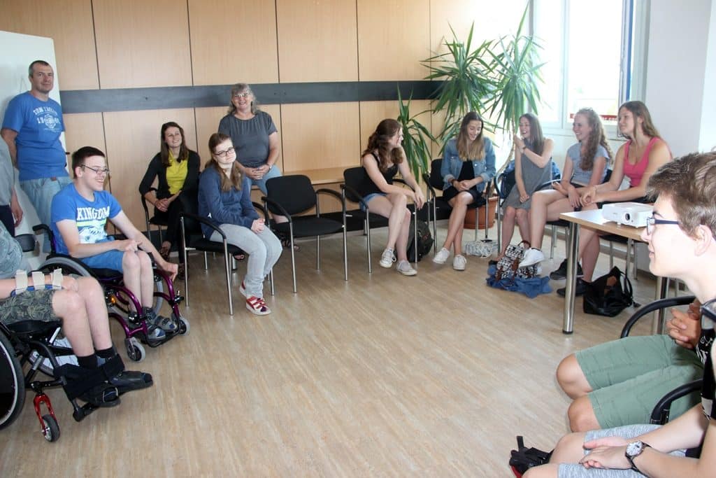 Ein Foto von der BeKu plus. Alle sitzen im Kreis und lachen.
