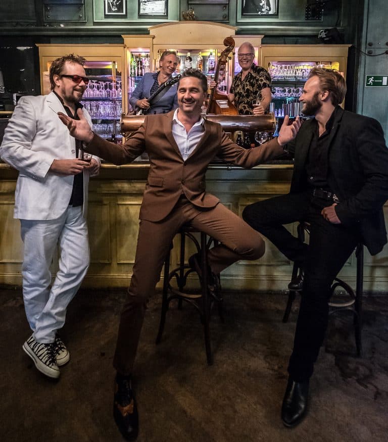 Ein Gruppenfoto von BB and the Blues Shacks in einer Bar.