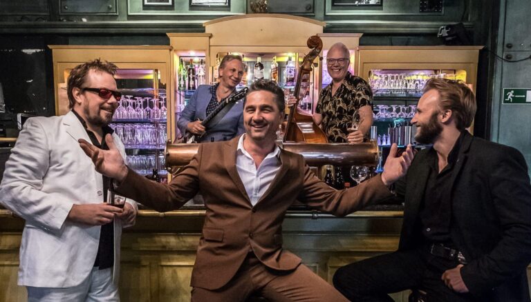 Ein Gruppenfoto von BB and the Blues Shacks in einer Bar.