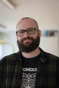 Ein Portrait von einen Kollegen der Freundlich grinst.