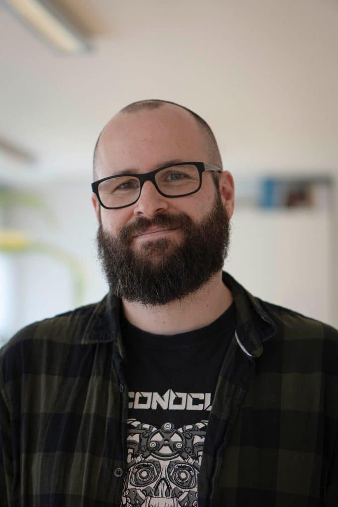 Ein Portrait von einen Kollegen der Freundlich grinst.