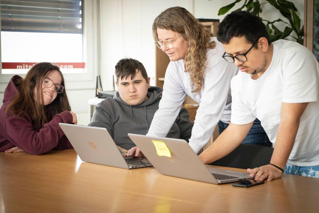 Die Ausbildnerin unterstützt Teilnehmer*innen dabei eine Präsentation zu machen.