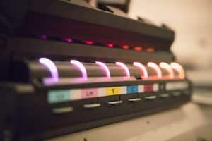 Ein Foto von den Farben des UV-Druckers. Man sieht verschiedene Farben mit Abkürzungen zu der richtigen Farbe.