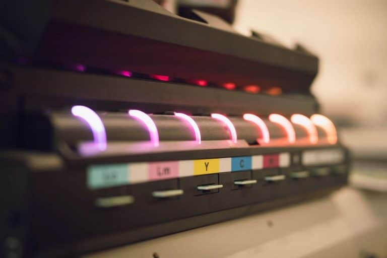 Ein Foto von den Farben des UV-Druckers. Man sieht verschiedene Farben mit Abkürzungen zu der richtigen Farbe.