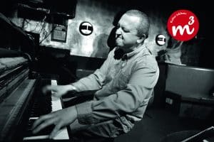 Der Jazz-Pianist Najponk während er mit geschlossenen Augen das Klavier spielt.