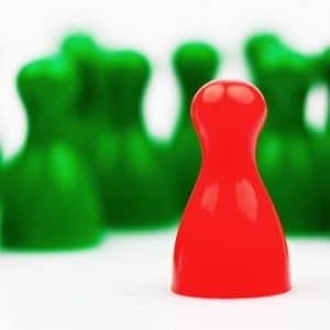 Eine Spielfigur steht abseits von anderen.